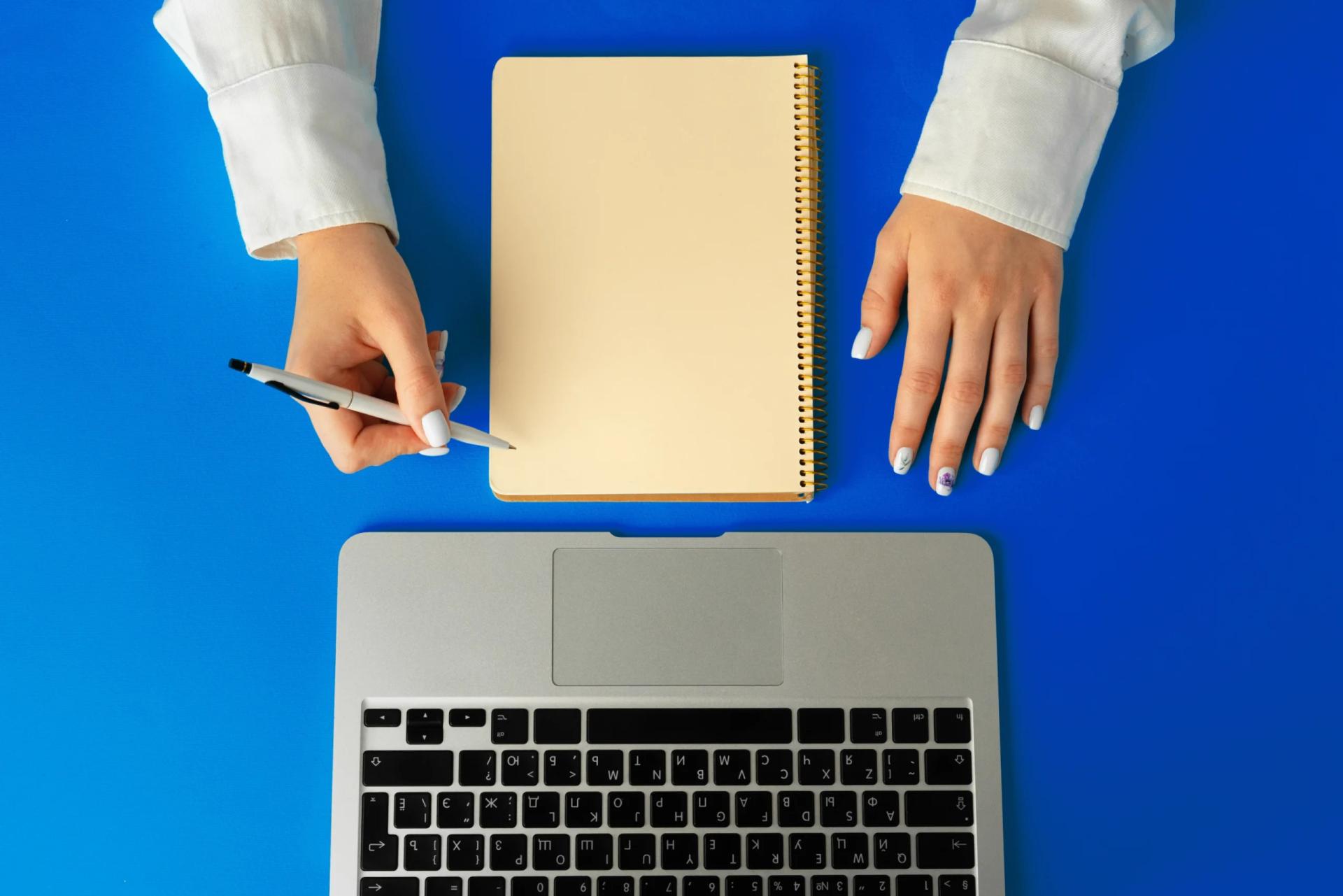 Hands on laptop with notebook