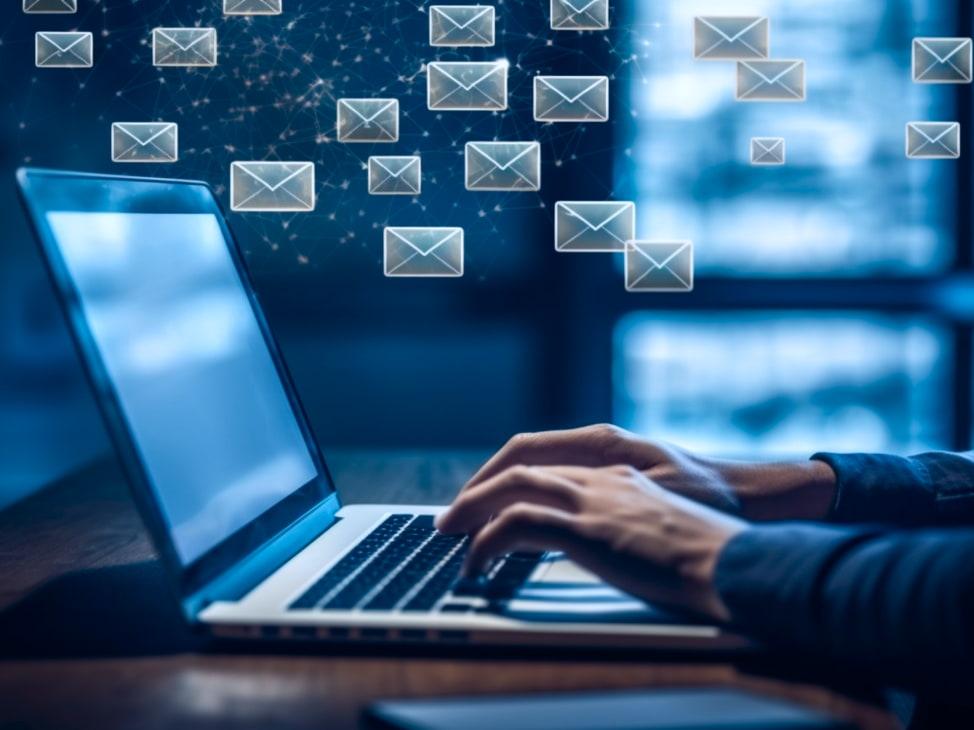 Person typing with email icons